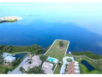 Stunning aerial view of the community, showcasing the water view, pool and lush landscaping at 401 Windrush Bay Dr, Tarpon Springs, FL 34689