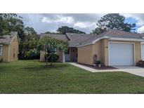 Well-maintained home features a lush green lawn and beautiful landscaping at 4206 Revere Cir, New Port Richey, FL 34653