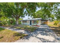Charming single-story home with a covered parking area and mature trees, offering shade and curb appeal at 6304 S S Grady Ave, Tampa, FL 33616