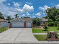 Charming single-story home with a well-manicured lawn, mature trees and a three car garage at 920 Tuscanny St, Brandon, FL 33511