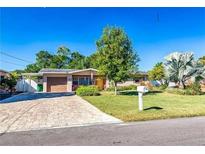 Charming single-story home with a well-maintained lawn and inviting curb appeal on a sunny day at 10218 N Fleetwood Dr, Tampa, FL 33612