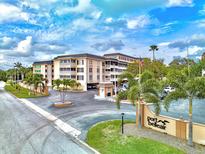 Lovely condo complex with an elegant entrance, circular driveway, and lush landscaping at Port Belleair at 139 Bluff View Dr # 405, Belleair Bluffs, FL 33770