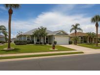 Charming single-story home with a well-manicured lawn, mature trees, and a two-car garage at 1607 Alexander Crossing Way, Sun City Center, FL 33573