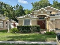 Charming single-Gathering home featuring a well-manicured lawn and lush landscaping at 19743 Ellendale Dr, Land O Lakes, FL 34638