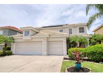 Inviting two-story home showcasing a three-car garage, well-maintained landscaping, and a neutral color palette at 2228 Hannah S Way, Dunedin, FL 34698