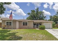Charming single-story home with a well-manicured lawn and an American flag at 2415 York N St, St Petersburg, FL 33710