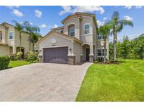 Charming two-story home with a paved driveway, two car garage, and lush green lawn at 30326 Ceasar Park Dr, Wesley Chapel, FL 33543