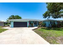 Charming one-story home with a two-car garage, manicured lawn, and lovely front yard landscaping at 3312 Kenmore Dr, Sarasota, FL 34231