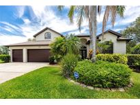 Beautiful single Gathering home with a well manicured yard, a two car garage, and mature landscaping in front at 335 Palmdale Dr, Oldsmar, FL 34677