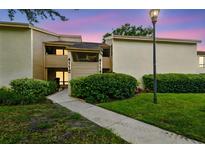 Charming condo featuring well-maintained landscaping and a inviting walkway leading to the front entrance at 4114 Pinelake Ln # 202, Tampa, FL 33618