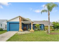 Charming single-story home features a blue exterior with stone accents and a well-manicured lawn at 7810 Flintlock Dr, Port Richey, FL 34668