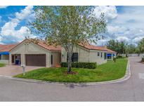 Charming villa with a well-maintained lawn, mature tree, and a barrel tile roof at 8701 40Th N Ln, Pinellas Park, FL 33782