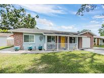 Charming single-story home with a sunny yellow door and stone accents at 9056 108Th Ave, Seminole, FL 33777
