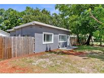 Charming home featuring a gray exterior, well-maintained fenced yard, and a cozy side patio at 9310 N 12Th St, Tampa, FL 33612