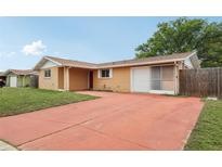 Charming single-story home with a spacious front yard and an extended red driveway at 10336 Alice M Ct, Port Richey, FL 34668