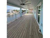 Spacious covered porch with ceiling fans and canal views, perfect for outdoor relaxation and entertaining at 15550 Bertram Dr, Hudson, FL 34667