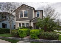 Inviting two-story home with lush landscaping, manicured shrubbery, and a beautiful brown and beige color palette at 4146 Bexley Village Dr, Land O Lakes, FL 34638