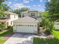 Two-story home with a two-car garage and a well-maintained lawn in a suburban neighborhood at 9329 Wellstone Dr, Land O Lakes, FL 34638