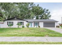 Charming single-story home with a painted brick facade, lush landscaping, and inviting curb appeal at 1008 Shangri La Dr, Seffner, FL 33584