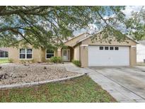 Charming single-story home featuring a well-manicured lawn and a two-car garage at 10304 Rainbow Oaks Dr, Hudson, FL 34667