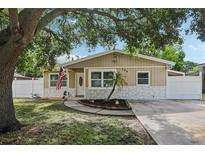 Charming single-story home with a well-manicured lawn, mature tree, and quaint curb appeal at 109 Emerald Ln, Largo, FL 33771