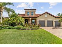 Charming, one-story home boasts a terracotta roof, three-car garage, and lush landscaping at 165 Mobbly Bay Dr, Oldsmar, FL 34677