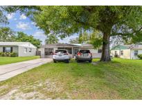 Charming single-story home featuring a well-manicured lawn and mature shade tree in a sunny residential neighborhood at 1711 W Followthru Dr, Tampa, FL 33612