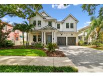 Stunning two-story modern farmhouse exterior with a manicured lawn and a two-car garage at 2604 W Jetton Ave, Tampa, FL 33629
