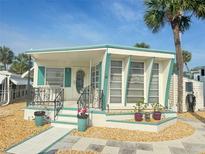 Charming mobile home featuring colorful trim, a welcoming front entrance, and a well-maintained landscaped yard at 4851 W Gandy Blvd # B7L36, Tampa, FL 33611