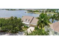 Waterfront home featuring lush landscaping, neutral paint, and a two-car garage at 5205 Brighton Shore Dr, Apollo Beach, FL 33572