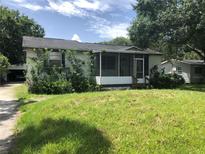 View of the home with a front porch and an overgrown front yard at 6403 Elliot Dr, Tampa, FL 33615