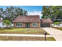 Charming single-story home with a well-maintained front yard, double door entry, and attached garage at 7206 Timber Ct, Tampa, FL 33625