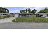 Exterior of a single-story house with a well-kept lawn and an attached garage at 7625 Marechal Ave, Port Richey, FL 34668