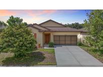 Charming single-story home features a well-maintained lawn, neutral colors, and a two-car garage at 15682 Stone House Dr, Brooksville, FL 34604