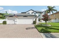 Charming two-story home with a three car garage, beautiful landscaping, and manicured lawn at 1802 Regal Mist Loop, Trinity, FL 34655