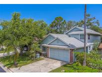 Charming home featuring well-maintained landscaping, mature trees, and an attached two-car garage at 1830 Springwood N Cir, Clearwater, FL 33763
