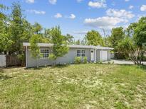 Charming single-story home with a well-manicured lawn and mature trees, perfect for serene living at 1843 Berg Rd, Holiday, FL 34690