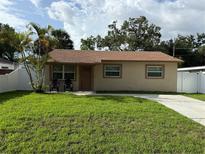 Charming single-story home with well-maintained lawn, complemented by mature trees and a concrete driveway at 1913 W Saint Conrad St, Tampa, FL 33607