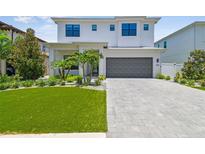 Stunning two-story home with manicured lawn, paver driveway, and gray garage door at 4109 W Inman Ave, Tampa, FL 33609