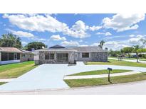 Charming single-story home boasting stone accents, a spacious driveway, and well-maintained landscaping at 4652 Swallowtail Dr, New Port Richey, FL 34653