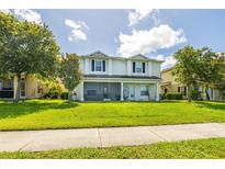 Charming two-story home featuring a well-manicured lawn and covered porch with a screened in lanai at 4743 Somerset Hill Ln, Riverview, FL 33578