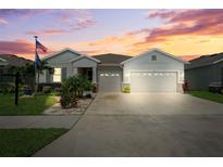 Charming single-story home featuring a well-manicured lawn, Florida landscaping, and a two-car garage at sunset at 537 Ocean Spray Dr, Ruskin, FL 33570
