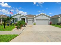 Charming single-story home with manicured lawn and three-car garage in a Gathering-friendly community at 537 Ocean Spray Dr, Ruskin, FL 33570