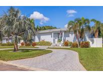 Beautiful single story home with a circular driveway and gorgeous tropical landscaping at 827 Placido Ne Way, St Petersburg, FL 33704