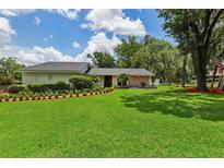 Beautifully landscaped front yard with lush green lawn and manicured hedges and flowerbeds enhance this home's curb appeal at 126 Holly Tree Ln, Brandon, FL 33511