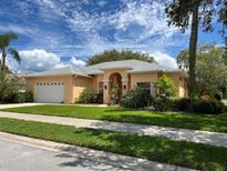 Charming single-story home with an attached two-car garage and beautifully landscaped front yard at 2406 Dana Dr, Safety Harbor, FL 34695