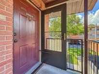 Exterior view of the front door with security screen and a glimpse of the outdoor landscape at 2442 Enterprise Rd # 6, Clearwater, FL 33763