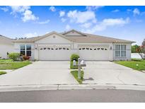 Charming duplex featuring a well-manicured lawn and a double garage at 30247 Emmetts Ct, Wesley Chapel, FL 33543