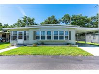 Charming single-story home featuring a covered carport and well-maintained front lawn at 37812 Valencia Ave, Zephyrhills, FL 33541