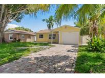 Charming yellow single Gathering home with a brick driveway and a one car garage at 4242 7Th N Ave, St Petersburg, FL 33713